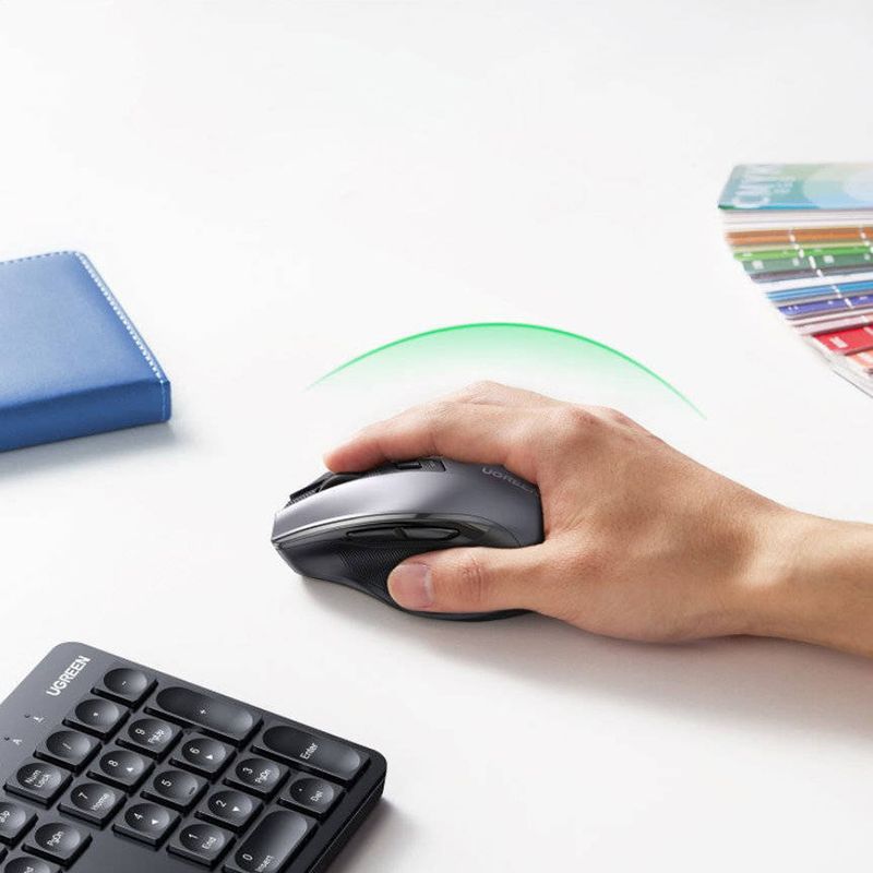 Mouse del combo inalámbrico Ugreen 2.4 GHz, sensor óptico de 4000 DPI con diseño ergonómico, color negro, vista en uso, sobre escritorio con mano utilizando el mouse