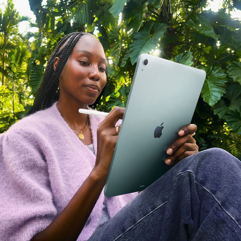 Imagen referencial de joven utilizando el iPad Air de 11 pulgadas (M3) con el Apple Pencil en un entorno exterior, destacando su versatilidad para la creatividad y el diseño, mostrado en plano medio fondo desenfocado