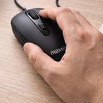 Mouse alámbrico Maxell MOWR-105C en uso sobre escritorio de madera destacando su diseño ergonómico y botones de navegación rápida