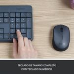 Combo inalámbrico Logitech MK235, teclado de tamaño completo y mouse compacto con receptor USB, color negro, vista en uso, sobre escritorio con mano utilizando el teclado